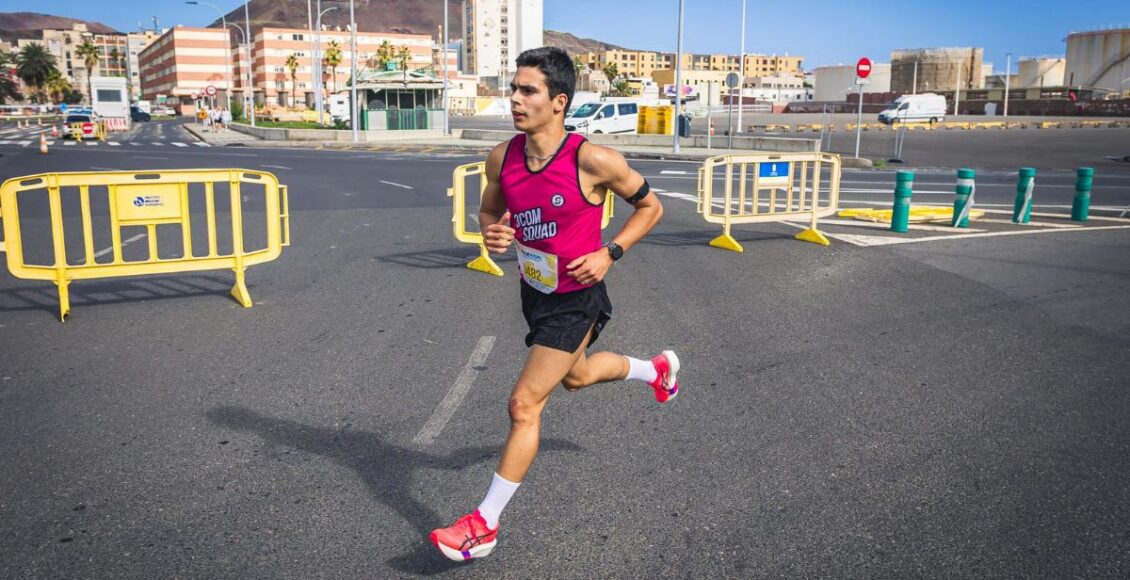 1 hombre corriendo en una carrera de atletismo y detrás unas vallas – 3com squad